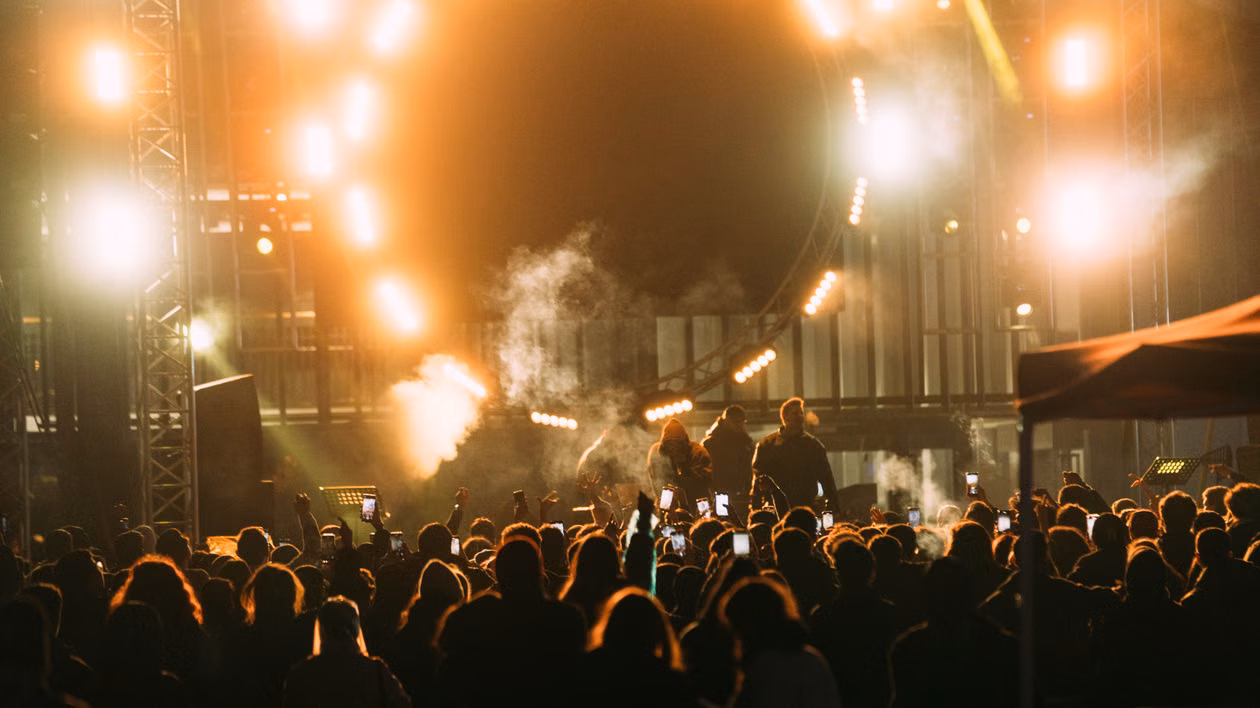 A concert crowd beneath a canopy of stage lights